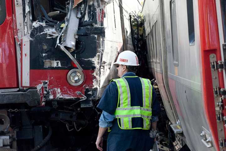 National Transportation Safety Board workers inspect the damage at the site of the collision between two Metro North trains on the Bridgeport-Fairfield border.