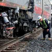 <p>Rail workers inspect the area of Friday&#x27;s train derailment and collision along the Bridgeport-Fairfield border.</p>