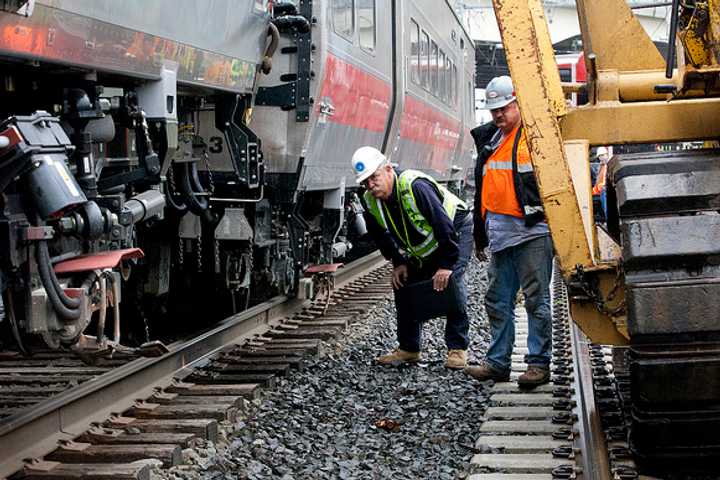 Rail workers inspect the area of Friday&#x27;s train derailment and collision along the Bridgeport-Fairfield border.