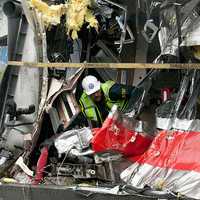 <p>A National Transportation Safety Board worker inspects one of the trains damaged in the collision last Friday on the Bridgeport-Fairfield border.</p>