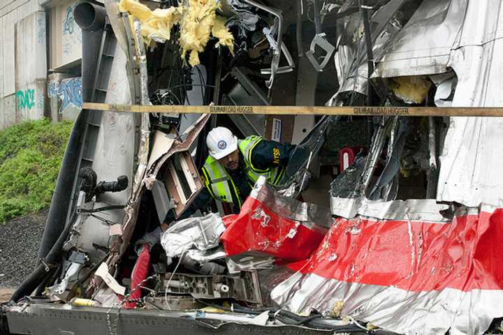 A National Transportation Safety Board worker inspects one of the trains damaged in the collision last Friday on the Bridgeport-Fairfield border.