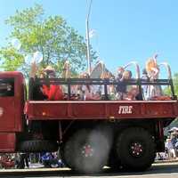 <p>Kids wave from a giant truck from the fire department. </p>