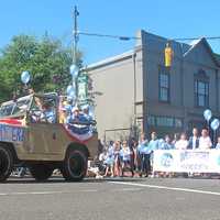 <p>A brightly colored jeep leads soccer players along the parade route. </p>