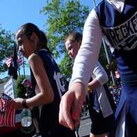 <p>Cheerleaders hand out flags along the parade route in Westport. </p>