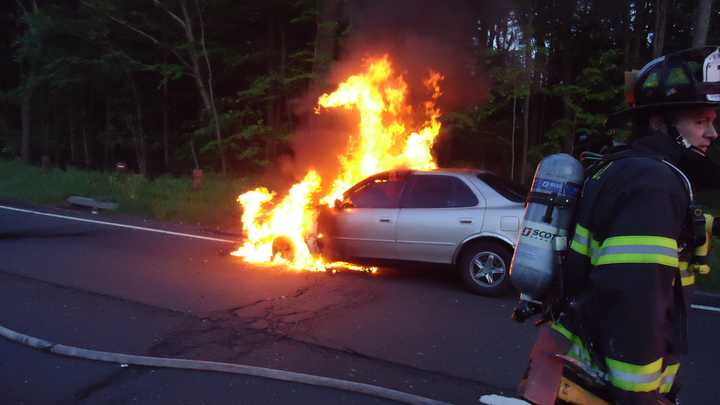 A 1992 Toyota Camry is fully engulfed in flames Monday night on the northbound Merritt Parkway. 