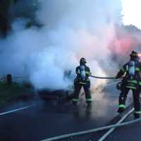 <p>Firefighters work to put out the blaze on the Merritt Parkway. </p>