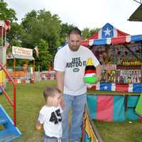 <p>White Plains residents Massimo Pulvirenti teaches son Nicholas a carnival game at Yorktown&#x27;s Firefighters Carnival Saturday.</p>