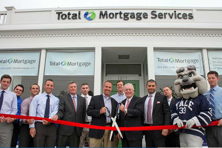 Fairfield First Selectman Michael Tetreau cuts the ribbon on Total Mortgage&#x27;s new branch with managers Joe Bartolomeo and Thomas Bepko and other staff members.