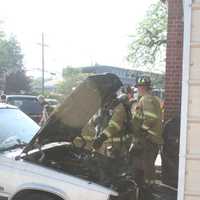 <p>Firefighters work to knock out a fire in a car in New Canaan. The blaze spread to the garage. </p>