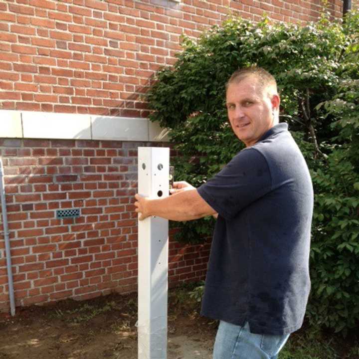 Neil Rea, project manager of Electrical Services Group, installs a Bruce Bennett Nissan-branded LEAF Charging Station at The Ridgefield Playhouse this week.