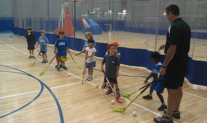 Greg Janos, right, teaches Floorball to children during a clinic at Chelsea Piers Connecticut in Stamford earlier this year.