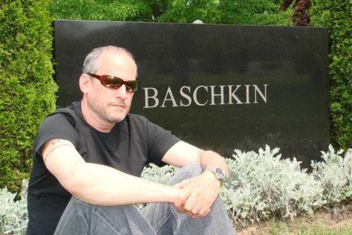 Laurance Baschkin sits by the headstone of family members. There are 18 cemeteries in Pound Ridge.