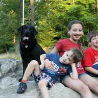 <p>Left to right: Guiding Eyes for the Blind stud dog Cosmo with Adam, Madelyn and Andrew Barti.</p>