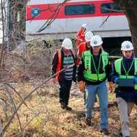 <p>NTSB officials retrieve an event recorder from the derailed Metro-North train in the Bronx.</p>