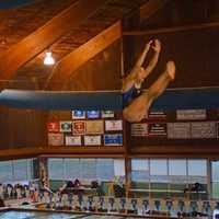 <p>New Canaan diver Kylie Towbin hits the pike position off of the 3-meter board.</p>