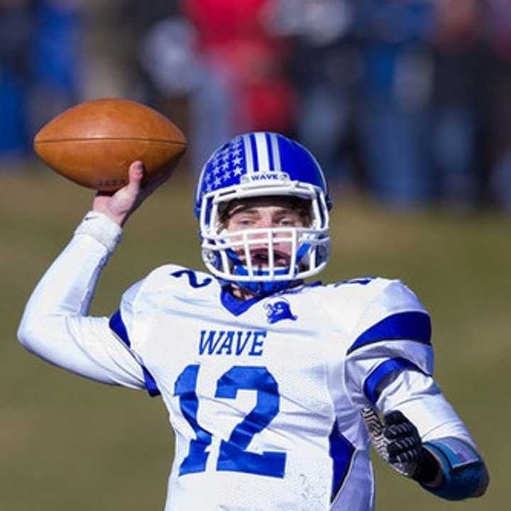 Darien quarterback Silas Wyper throws to a receiver during the Blue Wave&#x27;s win over New Canaan on Thanksgiving. The two teams will face off Saturday in the Class L final.