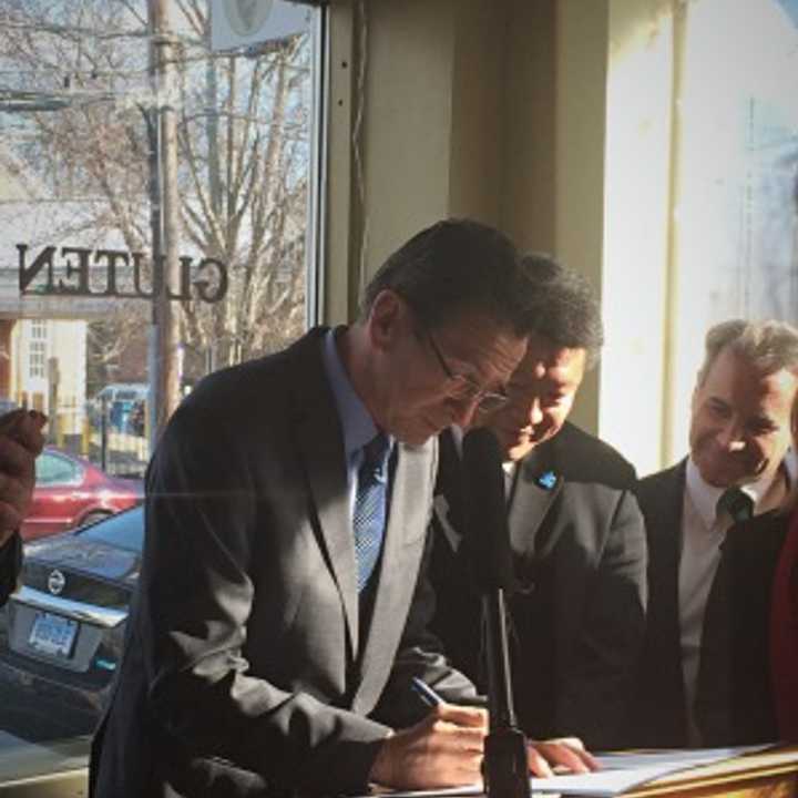 Gov. Dannel Malloy signs the GMO labeling law in Fairfield&#x27;s Catch A Healthy Habit Cafe with local lawmakers and supporters. 