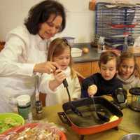 <p>Students at CCK Preschool get involved in the preparation of the food for their annual Thanksgiving feast. Pictured here: Mrs. Ilene Schiff with left to right Heather Martinsen, Owen Lishawa, Sylvia Candee</p>