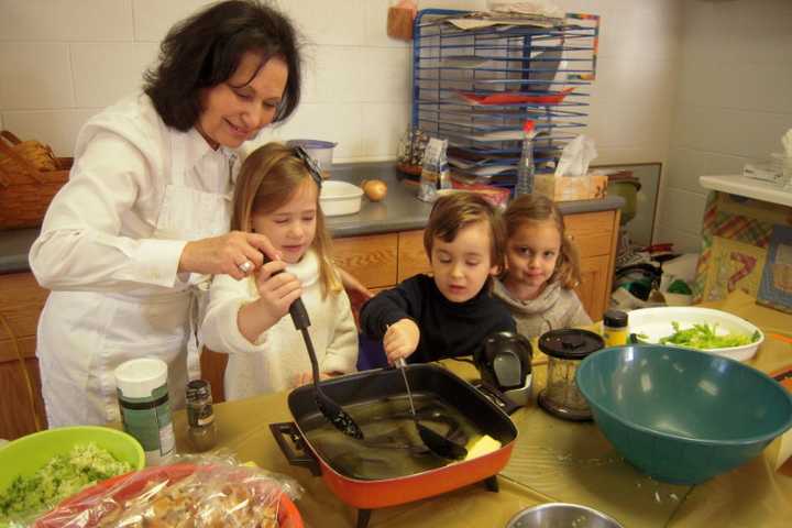 Students at CCK Preschool get involved in the preparation of the food for their annual Thanksgiving feast. Pictured here: Mrs. Ilene Schiff with left to right Heather Martinsen, Owen Lishawa, Sylvia Candee