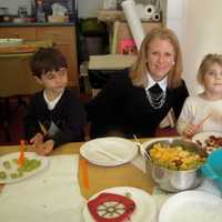 <p>Mrs. Maureen Redmond with left to right Chase Adams, Lizzy Wright, Michela Guccione prepare for the CCK Preschool Thanksgiving feast.</p>