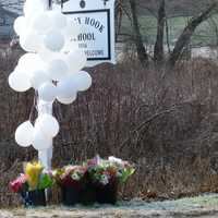 <p>Balloons and flowers honor the fallen students and educators at the sign for Sandy Hook School in Newtown, Conn.</p>