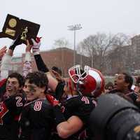 <p>New Canaan players celebrate after beating Darien on Saturday in the Class L football state championship game.</p>