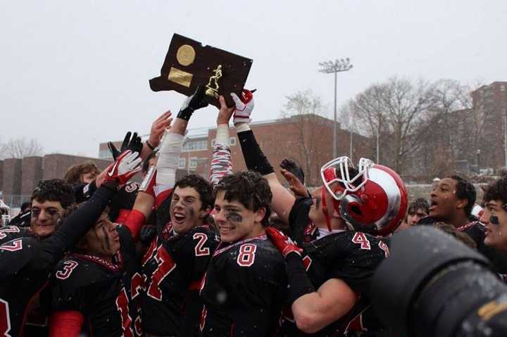 New Canaan players celebrate after beating Darien on Saturday in the Class L football state championship game.