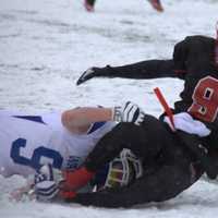 <p>New Canaan&#x27;s Cole Turpin hangs on to the football as he&#x27;s tackled by a Darien defender.</p>