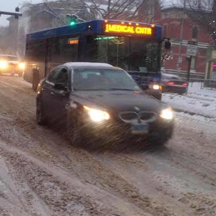 A HART bus makes its way down a snow-covered Main Street in Danbury late Tuesday afternoon. 