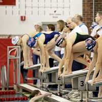 <p>Swimmers get ready to launch off of the starting blocks.</p>