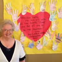 <p>&quot;Grandma Betty&quot; standing with a project made for her by students.</p>