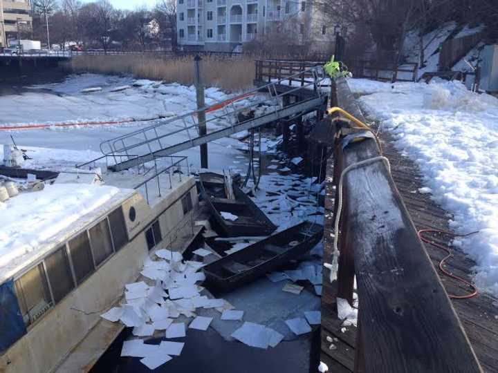 A houseboat is sunken in the ice of the Norwalk River at the Oyster Bend Marina on Saturday. 