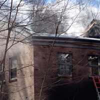 <p>Smoke billows from the remains of the Goldens Bridge fire station on Monday morning.</p>