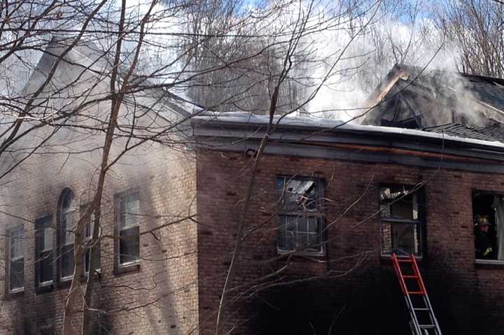 Smoke billows from the remains of the Goldens Bridge fire station on Monday morning.