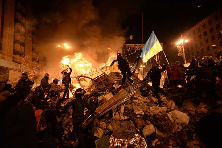 The state flag of Ukraine is carried by a protester to the heart of clashes in Kiev, Ukraine, on Feb. 18.