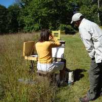 <p>Painter Dmitri Wright works with a student painting en plein air at Weir Farm National Historic Site.</p>