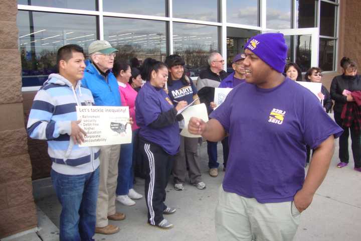 Norwalk Common Council member David Watts leads protesters in a chant for an end to income inequality.