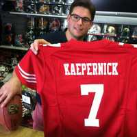 <p>Mark Bisanzo, left, owner of Bruce Park Sports, and Nick Chapar, assistant manager, hold a Colin Kaepernick jersey. Bisanzo said he will wait to see if gay NFL rookie Michael Sam makes his team before deciding whether he will stock the jersey.</p>