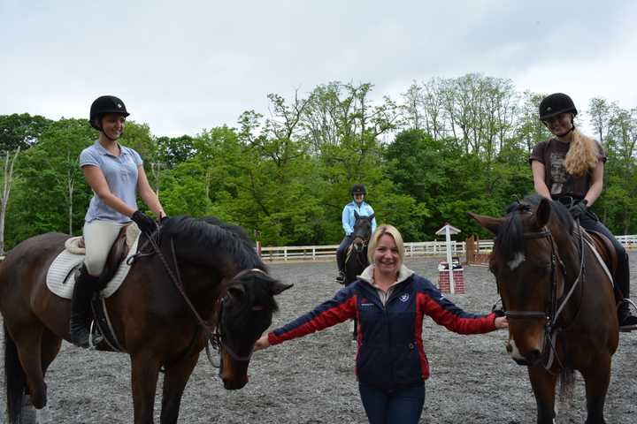 Ashley Yozzo poses for a photo with horses at Summit Farm in North Salem.