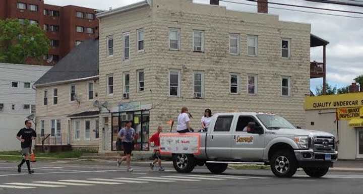 The runner with the Special Olympics torch makes the turn from Main Street onto South Street near Rogers Park in Danbury on Friday morning. 