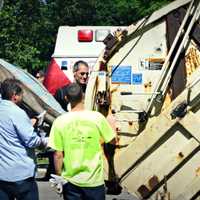 <p>Volunteers bring trash to dispose of in the garbage truck. </p>