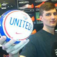 <p>Soccer &amp; Rugby Imports assistant manager Austin Murray holds a small U.S. soccer ball. He said the 42 W. Putnam Ave., store has seen steady business leading up to the World Cup, which begins Thursday in Brazil.</p>