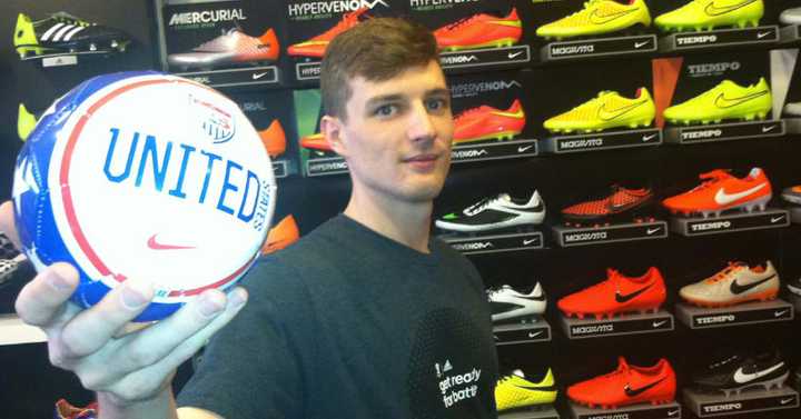 Soccer &amp; Rugby Imports assistant manager Austin Murray holds a small U.S. soccer ball. He said the 42 W. Putnam Ave., store has seen steady business leading up to the World Cup, which begins Thursday in Brazil.