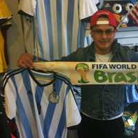 <p>Maurice Cabrera, 26, from Port Chester, N.Y., holds an Argentina jersey and a World Cup scarf at Soccer &amp; Rugby Imports at 42 W. Putnam Ave., Wednesday. The World Cup begins Thursday in Brazil.</p>