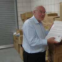 <p>Needs Clearing House Co-President Joe Kaliko holds up one of the 14,000 bed sheet sets donated by Starwood and temporarily housed at Westy Self Storage in Norwalk.</p>