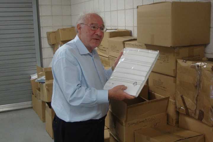 Needs Clearing House Co-President Joe Kaliko holds up one of the 14,000 bed sheet sets donated by Starwood and temporarily housed at Westy Self Storage in Norwalk.