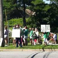 <p>Fairfield residents hold a protest Saturday as they seek to have sound barriers built at the I-95 northbound rest area. Construction materials can be seen behind them at the Exit 22 rest stop.</p>