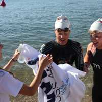 <p>Swimmers get a warm greeting from volunteers after the chilly swim.</p>