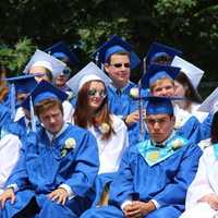 <p>Students wait and watch as their classmates receive diplomas. </p>