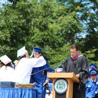 <p>Graduates share a moment on the stage before getting their diplomas. </p>